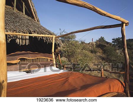 Stock Photograph - Bed Outside Thatched Hut. Fotosearch