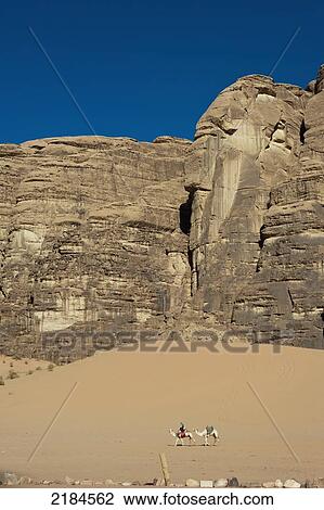 Bedouin Riding A Camel In Desert, Wadi Rum (The Valley Of The Moon), Jordan, Middle East View Large Photo Image Stock Image - Bedouin Riding A Camel In Desert, Wadi Rum (The Valley Of The Moon), Jordan, Middle East. Fotosearch