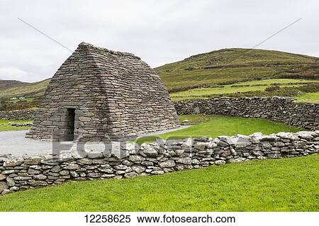 Beehive stone structure with stone fences and grassy hillside in the background, Gallarus Oratory; Gallarus, County Kerry, Ireland View Large Photo Image Stock Photography - Beehive stone structure with stone fences and grassy hillside in the background, Gallarus Oratory; Gallarus, County Kerry, Ireland. Fotosearch