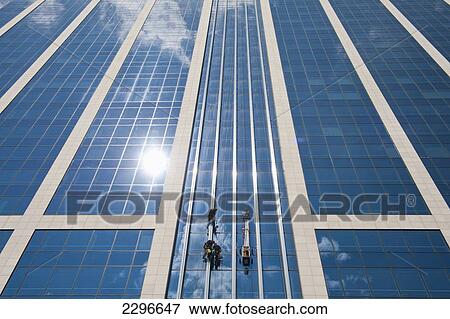 Stock Photo - Belgium, Men doing repair work whilst abseiling down office block; Brussels. Fotosearch