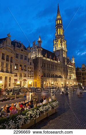 Stock Photo - Belgium, People at restaurant tables at dusk in Grand Place; Brussels. Fotosearch