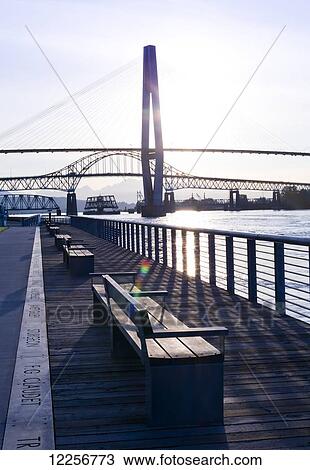 Benches along the waterfront with a bridge over the Fraser River at sunrise; New Westminster, British Columbia, Canada View Large Photo Image Stock Image - Benches along the waterfront with a bridge over the Fraser River at sunrise; New Westminster, British Columbia, Canada. Fotosearch