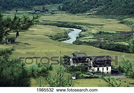 Stock Image - Bhutan, River winding through farmland and housing; Paro Valley. Fotosearch