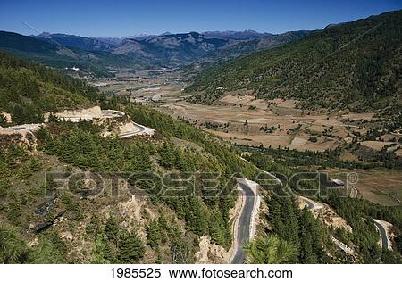 Stock Photography - Bhutan, Winding roads on hillside in rural landscape; Bumthang Valley. Fotosearch