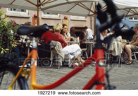 Stock Photo - Bicycle And People In Restaurants. Fotosearch
