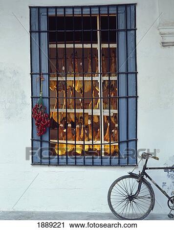 Stock Image - Bicycle Beside Butchers Shop Window. Fotosearch