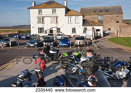 Stock Image - Bikers And Motorcycle, George Pub; West Bay, Jurassic Coast, Dorset, England. Fotosearch