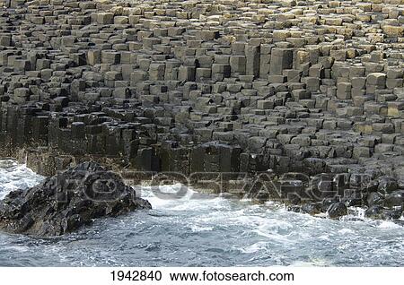 Stock Image - Black Basalt Columns Sticking Out Of The Sea, Giant's Causeway, Northern Ireland, United Kingdom. Fotosearch