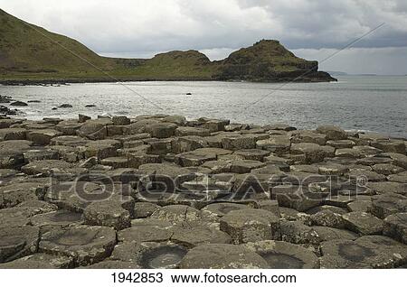Stock Image - Black Basalt Columns Sticking Out Of The Sea, Giant's Causeway, Northern Ireland, United Kingdom. Fotosearch