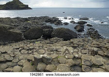 Stock Image - Black Basalt Columns Sticking Out Of The Sea, Giant's Causeway, Northern Ireland, United Kingdom. Fotosearch