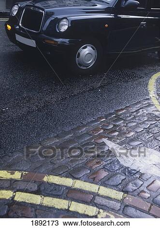 Stock Image - Black Cab And Cobbled Pavement. Fotosearch