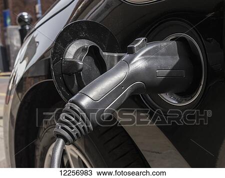 Stock Image - Black electric car recharging; London, England. Fotosearch