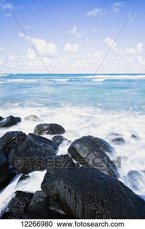 Stock Image - Black lava rocks along coast; Wailua, Kauai, Hawaii, United States of America. Fotosearch