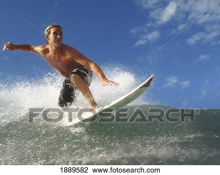 Stock Image - Blond Surfer On Crest Of A Wave, Low Angle View. Fotosearch