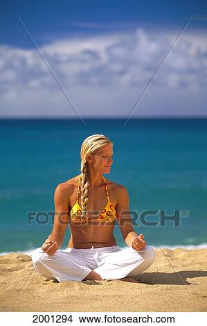 Picture - Blonde Woman Yoga On Sand, Turquoise Ocean Background White Clouds Along Horizon. Fotosearch