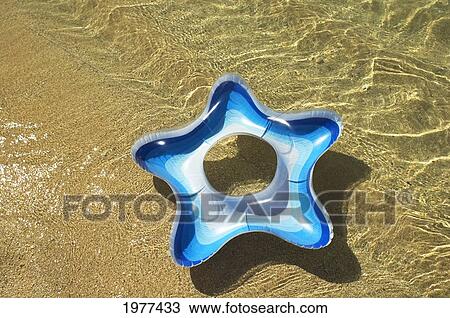 Blue And White Star Swim Ring In Shallow Water. View Large Photo Image Stock Image - Blue And White Star Swim Ring In Shallow Water.. Fotosearch