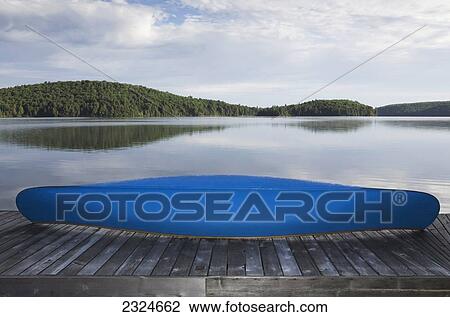 Stock Image - Blue Canoe On Cottage Dock, Algonquin Park, Ontario, Canada. Fotosearch