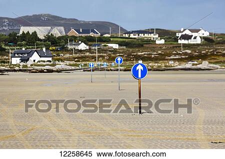 Blue signs with white arrows directing a tidal roadway to an island in the distance; Omey Island, County Galway, Ireland View Large Photo Image Stock Photography - Blue signs with white arrows directing a tidal roadway to an island in the distance; Omey Island, County Galway, Ireland. Fotosearch
