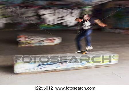 Stock Image - Blurred image of a skateboarder at the Southbank skateboard park; London, England. Fotosearch