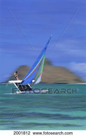 Stock Image - Blurred Image Of Person Sport Sailing, Blue Sky, Blue And Green Sail. Fotosearch