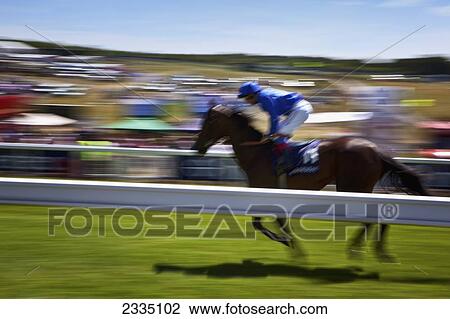 Stock Image - Blurred Motion Racehorse Running At Epsom Derby; London, England, Uk. Fotosearch