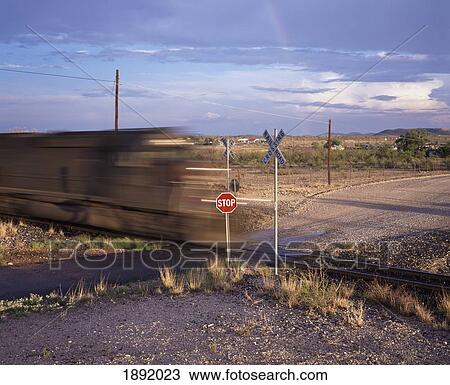 Stock Image - Blurred Train On Railroad Crossing. Fotosearch