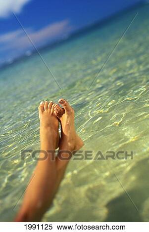 Stock Photography - Blurry Close-Up Of A Woman's Feet Above Clear Ocean Water, Blue Sky. Fotosearch