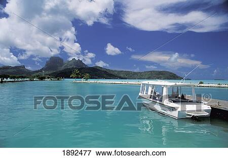Stock Photo - Boat Beside Jetty In Tranquil Bay. Fotosearch