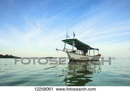 Stock Image - Boat moored in the water off Tui Beach, Koh Rong Island; Sihanoukville, Cambodia. Fotosearch