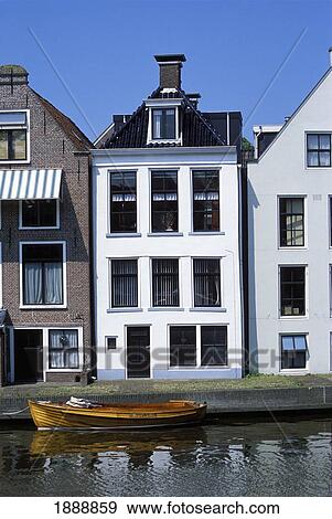 Stock Photo - Boat On Canal By Houses. Fotosearch