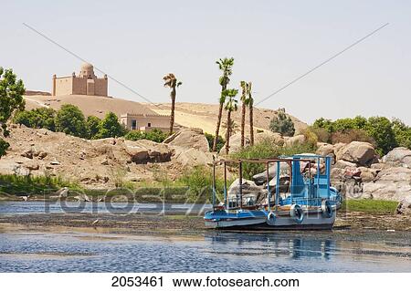 Stock Image - Boat On The Nile River And Mausoleum Of Mohammed Shah Aga Khan, Aswan, Egypt. Fotosearch