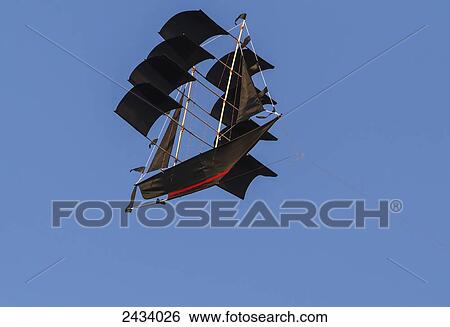 Boat-shaped kite flying over Tanah Lot, Bali, Indonesia View Large Photo Image Stock Photograph - Boat-shaped kite flying over Tanah Lot, Bali, Indonesia. Fotosearch