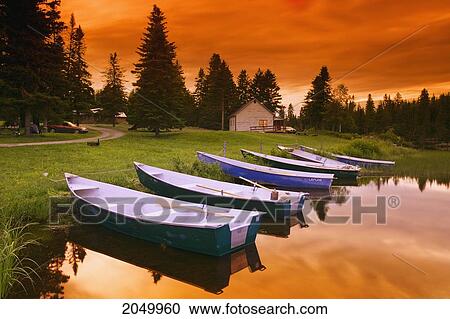 Stock Image - Boats And Cottage At Dusk, Rimouski Lake, Rimouski Wildlife Reserve, Bas-Saint-Laurent Region, Quebec. Fotosearch