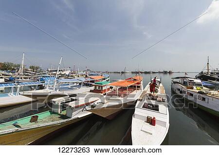 Boats and pinisi, traditional two masted wooden cargo sailing ships moored in Paotere Harbour, Makassar (Ujung Pandang), South Sulawesi, Indonesia View Large Photo Image Stock Image - Boats and pinisi, traditional two masted wooden cargo sailing ships moored in Paotere Harbour, Makassar (Ujung Pandang), South Sulawesi, Indonesia. Fotosearch