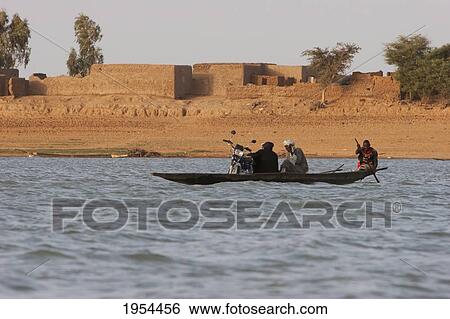 Stock Photograph - Boats and village along the shores of the Niger River between Mopti and Lake Debo, Mali. Fotosearch