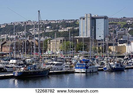 Stock Image - Boats in the marina along docks; Swansea, Wales. Fotosearch