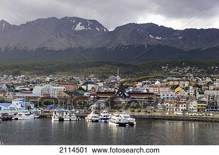Stock Image - Boats In The Water At The Waterfront Of A City With Mountains In The Background; Ushuaia Argentina. Fotosearch