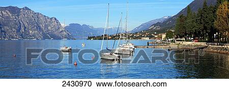 Stock Image - Boats moored in a harbour of Lake Garda; Malcesine, Verona, Italy. Fotosearch