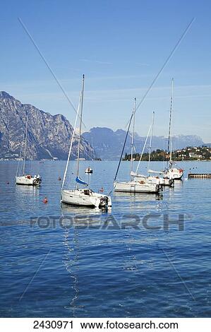 Stock Image - Boats moored in a harbour of Lake Garda; Malcesine, Verona, Italy. Fotosearch