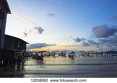 Boats moored in the harbour at sunset off Tui Beach, Koh Rong Island; Sihanoukville, Cambodia View Large Photo Image Stock Image - Boats moored in the harbour at sunset off Tui Beach, Koh Rong Island; Sihanoukville, Cambodia. Fotosearch