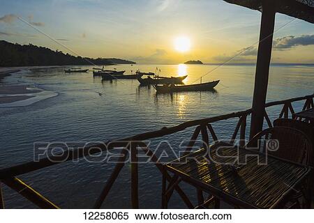 Stock Photography - Boats moored in the harbour at sunset off Tui Beach, Koh Rong Island; Sihanoukville, Cambodia. Fotosearch