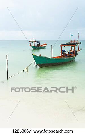 Stock Photo - Boats moored in the shallow water off Tui Beach, Koh Rong Island; Sihanoukville, Cambodia. Fotosearch