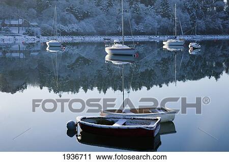 Stock Image - Boats Moored On Tranquil Water In The Winter; County Cork Ireland. Fotosearch