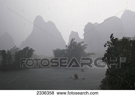 Boats On The River On A Rainy Day; Yangshuo, China View Large Photo Image Stock Photo - Boats On The River On A Rainy Day; Yangshuo, China. Fotosearch