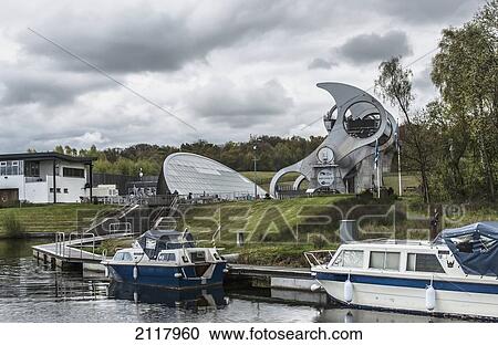 Stock Image - Boats On The Shoreline Of Union Canal With The Qin The Background; South Falkirk Scotland. Fotosearch