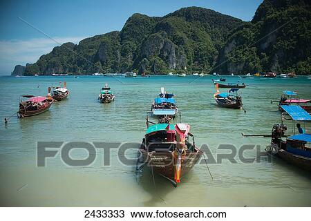 Stock Image - Boats sit in the bay of Koh Phi Phi Island in the Andaman Sea; Thailand. Fotosearch