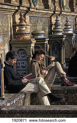 Stock Image - Book Reading Couple Relax At Tiled Plaza Espana. Fotosearch