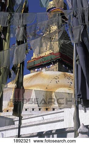 Stock Image - Boudhanath Stupa Through Prayer Flags. Fotosearch