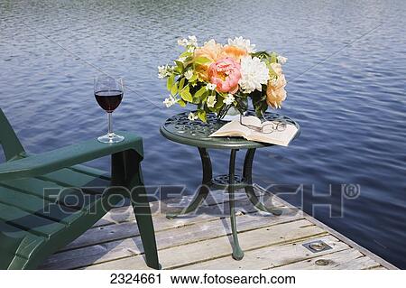 Stock Image - Bouquet Of Flowers With Wine, Book And Chair On A Cottage Dock, Ontario, Canada. Fotosearch