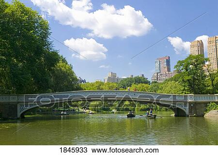 Stock Image - Bow Bridge And Boats In Central Park; Manhattan, New York, Usa. Fotosearch